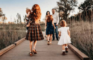 family playing on bridge in park